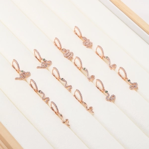 Boucles d'oreilles serpent en or rose avec cristaux blancs et yeux en pierre verte