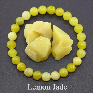 Macro shot of polished lemon jade beaded bracelet and raw natural yellow gemstones