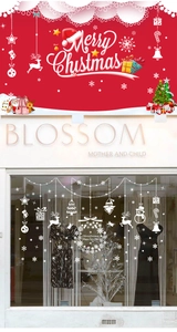 White Christmas window stickers featuring reindeer and snowflakes on glass shopfront