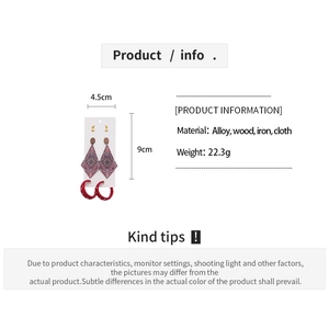 Detail view of ethnic wood and fabric earrings set with geometric shapes and red dots