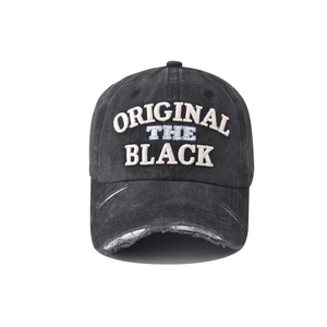 Macro detail of THE BLACK 3D embroidery and distressed frayed edges on washed cotton cap