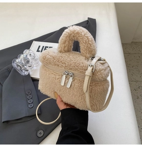 Detail of beige faux fur handbag showing plush texture and silver double zipper hardware