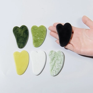 Set of 6 natural jade gua sha massage tools in assorted colors on a white background