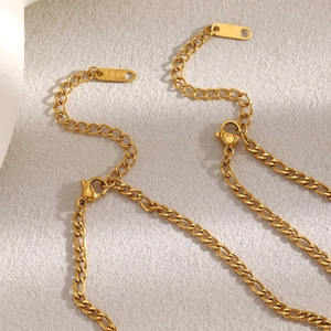 Detail of 18K gold-plated stainless steel Figaro chain with lobster clasp and 18K tag