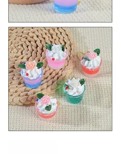 Close-up of miniature cream rose dessert charms with colorful cups and golden chains
