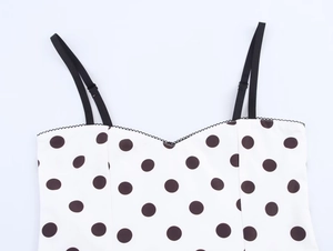 Détail du caraco à pois avec bretelles réglables et bordure ondulée au décolleté