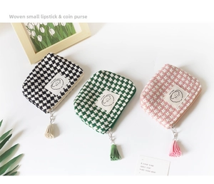 Mini checkered storage pouches with tassels for coins and lipstick organized on a desk