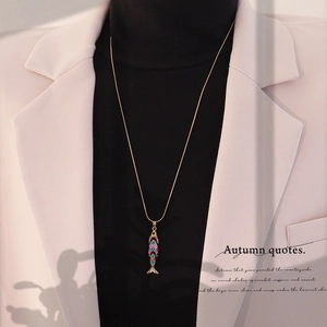 Detailed shot of a vintage koi fish pendant necklace with colorful enamel on a gold chain