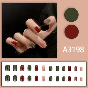 Christmas style press-on nails in deep green and wine red with gold foil accents