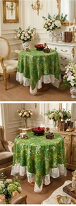 Close-up of white lace border on a round tablecloth with green leaves and gold flowers