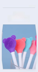 Close-up of double-sided silicone facial mask brush with soft cleansing bristles and applicator