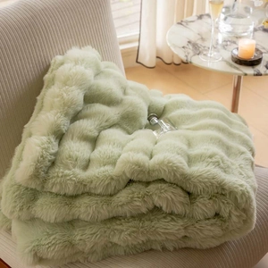 Detail of light green faux fur blanket with wave pattern on a modern living room sofa