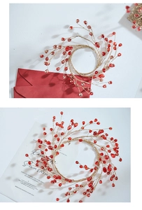 Detailed top view of handmade red crystal bead ornaments with golden wire on white background
