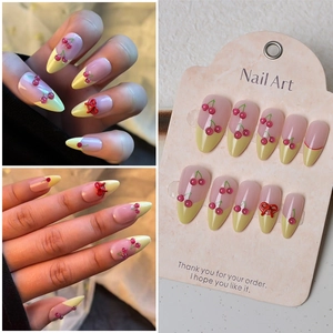French tip almond press-on nails with 3D cherry and red bow accents in pink and yellow