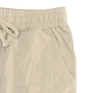 Detail of men linen trousers featuring elastic waistband with adjustable drawstring and pockets