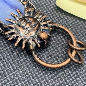 Detailopname van de retro zonnehanger met blauwe kyanietsteen en bronzen afwerking