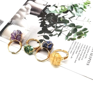 Detail of four handmade wire-wrapped raw agate rings with colorful natural stones