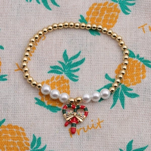Détail du bracelet de Noël avec perles dorées, perles blanches et breloque sucre d'orge en cœur