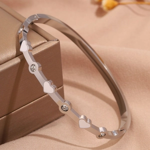 Vista macro di bracciale cuore in acciaio al titanio con strass su una scatola