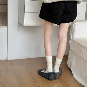 Detail of white cotton crew socks with Follow Your Heart embroidery and heart pattern
