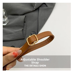Detail of adjustable brown faux leather shoulder strap with gold metal buckle for handbag