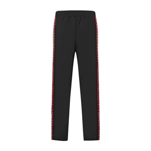 Detail view of black casual trousers with red plaid side stripes and elastic waist