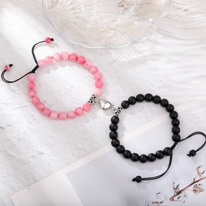 Detail of pink and black beaded couple bracelets with heart-shaped magnetic clasp