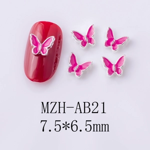Detail view of pink alloy butterfly nail charms sized 7.5x6.5mm with gold metal edges