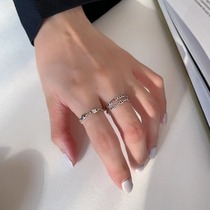 Close-up of minimalist 925 silver rings with chain and hollow circle designs