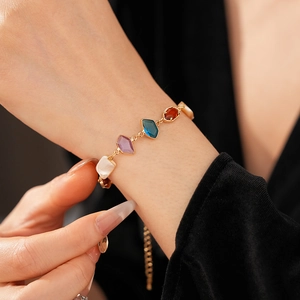 Détail d'un bracelet vintage doré orné de pierres précieuses colorées sur le poignet