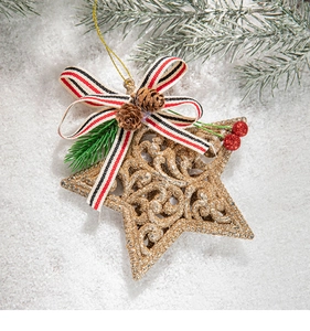 Golden glitter star ornament with pine cones and festive ribbon on snow background