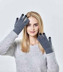 Detail of grey knitted gloves showing black touchscreen tips on fingers and ribbed cuffs