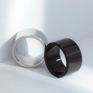 Macro shot of 12mm wide minimalist polished titanium steel rings in silver and black finish