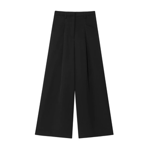 Détail du pantalon noir taille haute à jambes larges avec un drapé élégant et tissu lisse