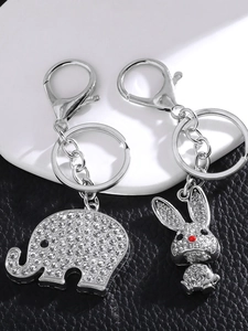 Detailed macro view of rhinestone elephant and rabbit keychains with silver lobster clasps