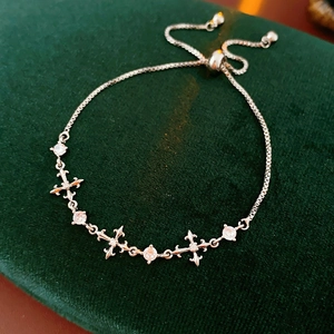 Detail view of silver zircon cross charm bracelet with adjustable sliding box chain