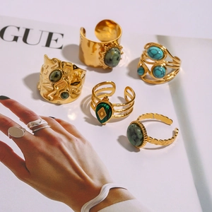 Gros plan d'un ensemble de bagues dorées vintage avec turquoise sur un magazine