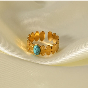Detail of 18K gold stainless steel open ring with oval turquoise and textured finish