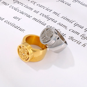 Detail of gold and silver steel rings with hollow Hamsa Hand and white zircon stones