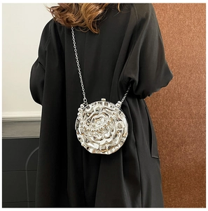 Close-up of a silver 3D rose-shaped metallic evening clutch bag with chain strap