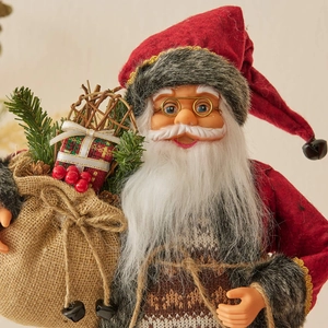 Standing Christmas Santa Claus doll in red knitted sweater holding a burlap gift bag