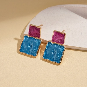 Detail of retro geometric earrings with purple and blue enamel in gold-plated square frames