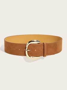 Detail of a brown suede waist belt featuring a polished gold horseshoe pin buckle