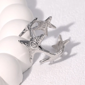 Macro detail of silver starfish open ring with polished metal texture on white background
