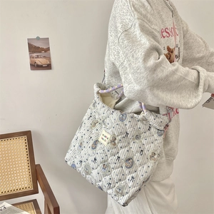 Detailed close-up of quilted tote bag with cute bear pattern and braided rope handle