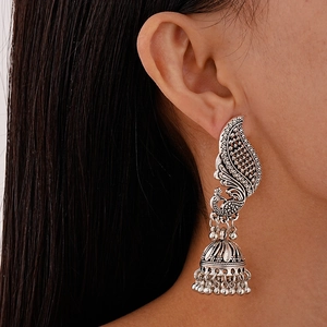 Vue rapprochée de boucles d'oreilles jhumka paon en argent vintage avec glands à clochettes