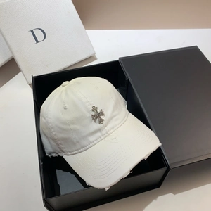 Detailed shot of white distressed baseball cap with metal cross in a black gift box