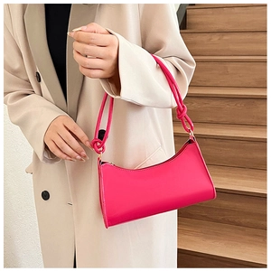 Detail of fuchsia baguette bag with a knotted strap and gold-tone hardware detail