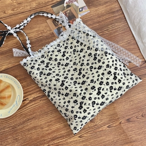 Detail of floral canvas tote bag with lace edges and daisy-shaped lace shoulder straps