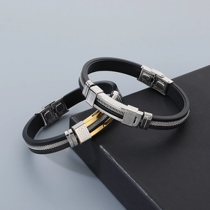 Detail of silicone and stainless steel bracelets with meander patterns on a gift box